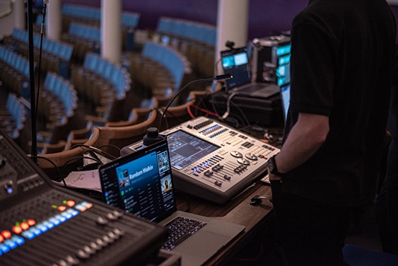 Technical production crew working on the mixing desk behind the scenes at an e.on event